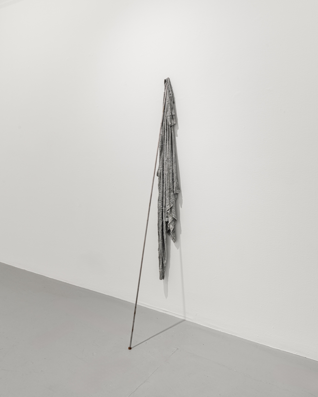 T-shirt on metal rod (2017), concrete, t-shirt, steel bar, copper penny; 72 x 8 in (183x20cm); ph. courtesy the artist and Galleria Macca